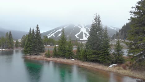 snow flurries on a turquoise pond in colorado with copper mountain resort in the background