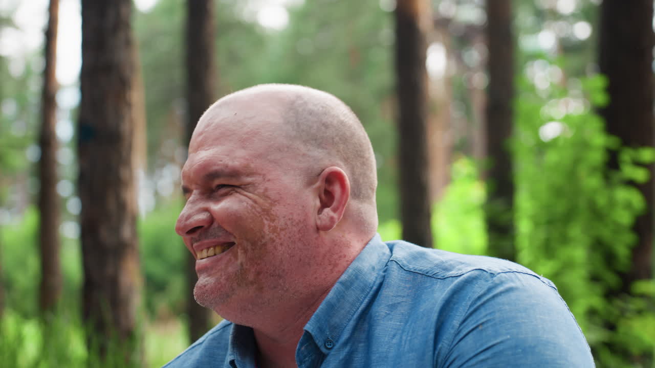 vista media de la cabeza de un miembro de la familia sonriendo cálidamente durante un picnic al aire libre en un exuberante bosque verde, mostrando satisfacción, felicidad y un ambiente tranquilo mientras disfruta de tiempo de calidad con sus seres queridos en la naturaleza