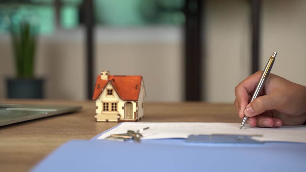 concepto de compra de una casa nueva - agente inmobiliario escribiendo documentos en la oficina