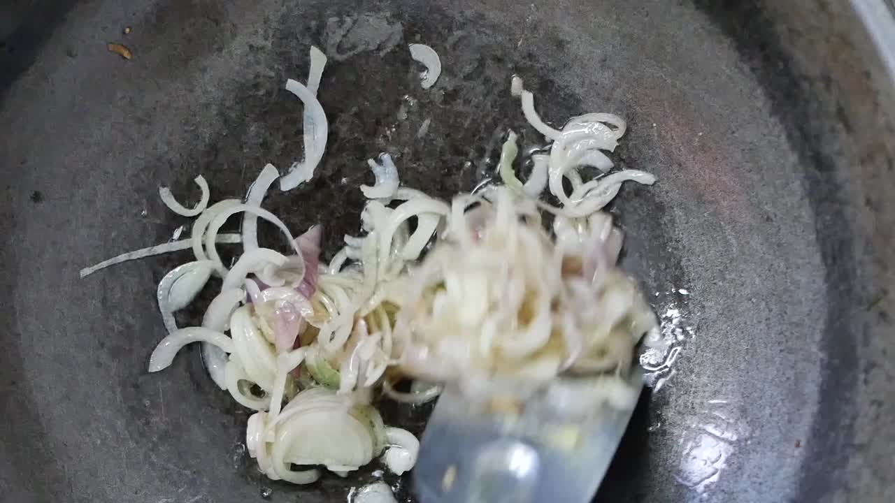 Frying sliced onions in a pan