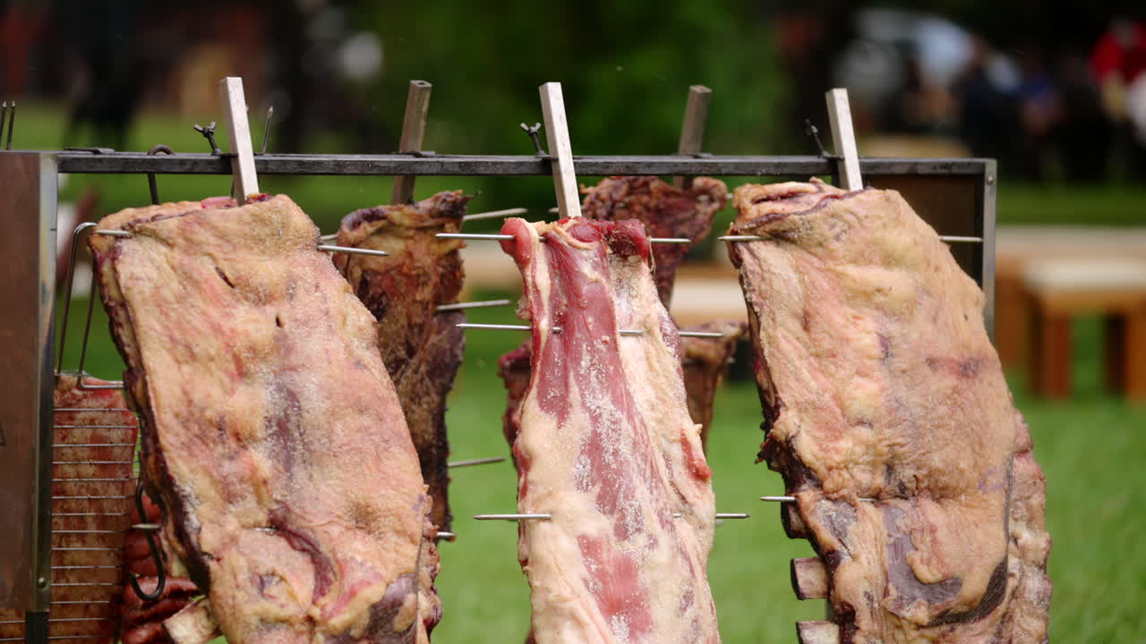 Traditional Argentinian asado with large beef cuts cooking on open fire grill outdoors, authentic barbecue culture and culinary heritage