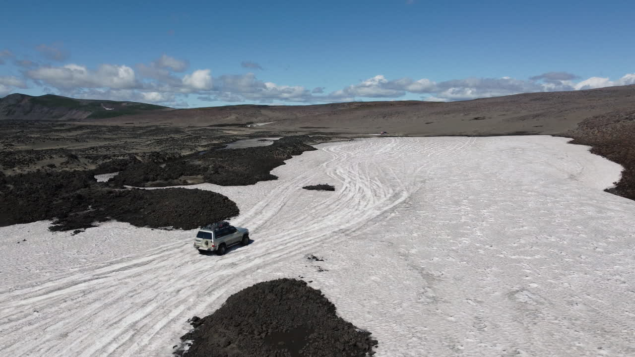 suv conduciendo alrededor del glaciar vista aérea
