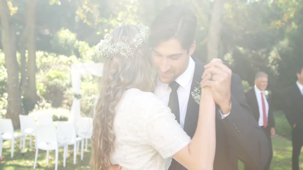 행복한 젊은 신랑과 신부가 춤을 추면서 서로 포옹하고 있습니다. 4k 4k