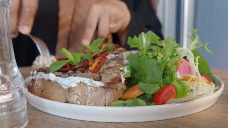 woman eating a delicious sandwich with salad