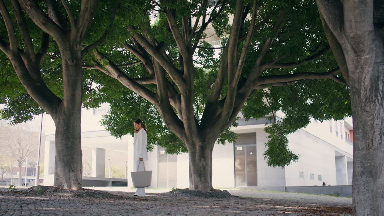 화려한 색 슈트를 입은 멋진 여성이 전화로 이야기하고 있습니다.