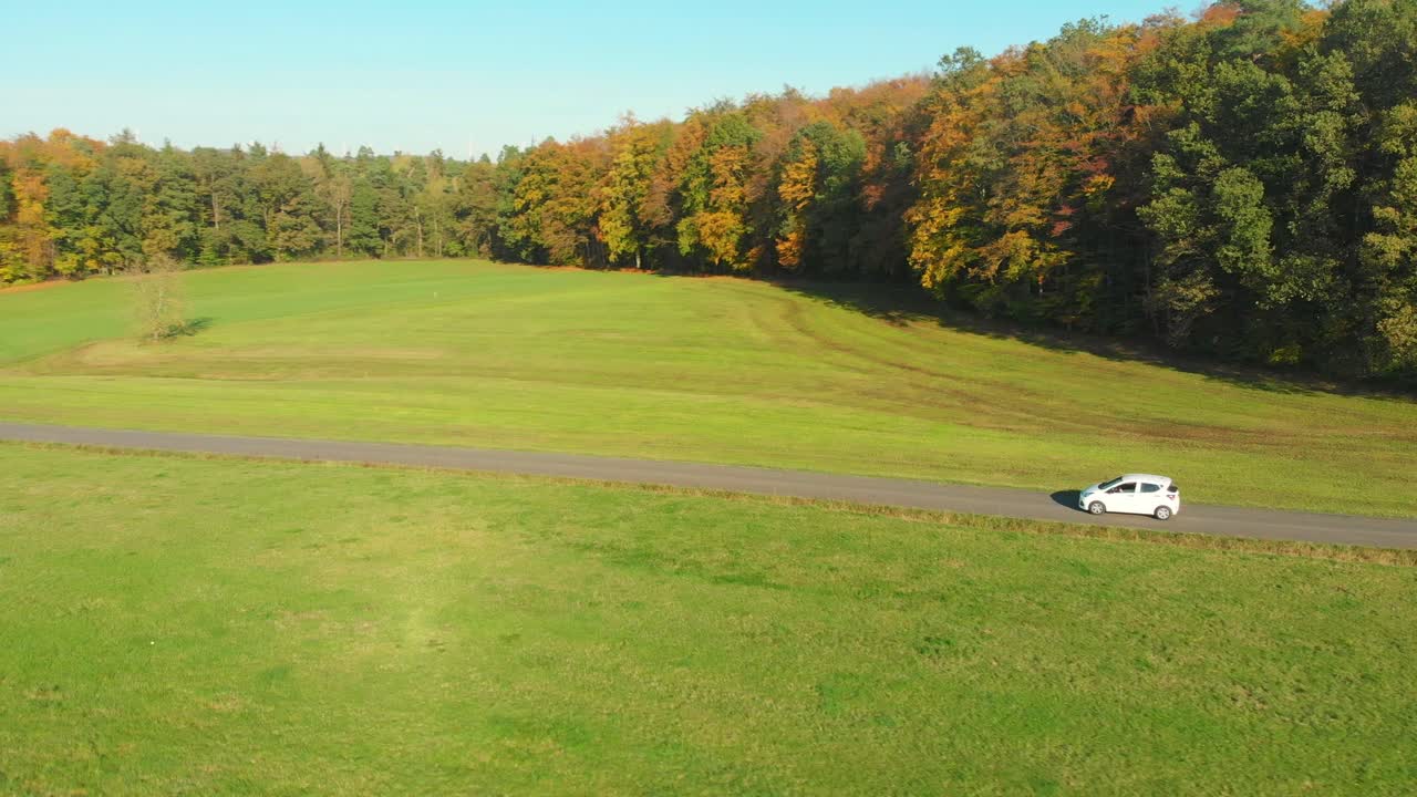 가을철 아름다운 풍경을 달리는 흰색 자동차
