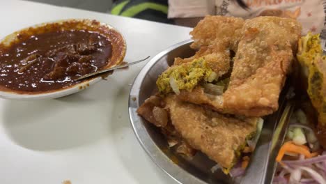 spicy indian curry and fried pastry