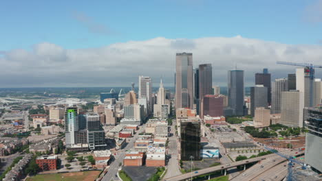 Aerial-view-tall-modern-office-buildings-downtown.-Group-of-skyscrapers-behind-highway.-Pedestal-down-footage-from-drone.-Dallas,-Texas,-US