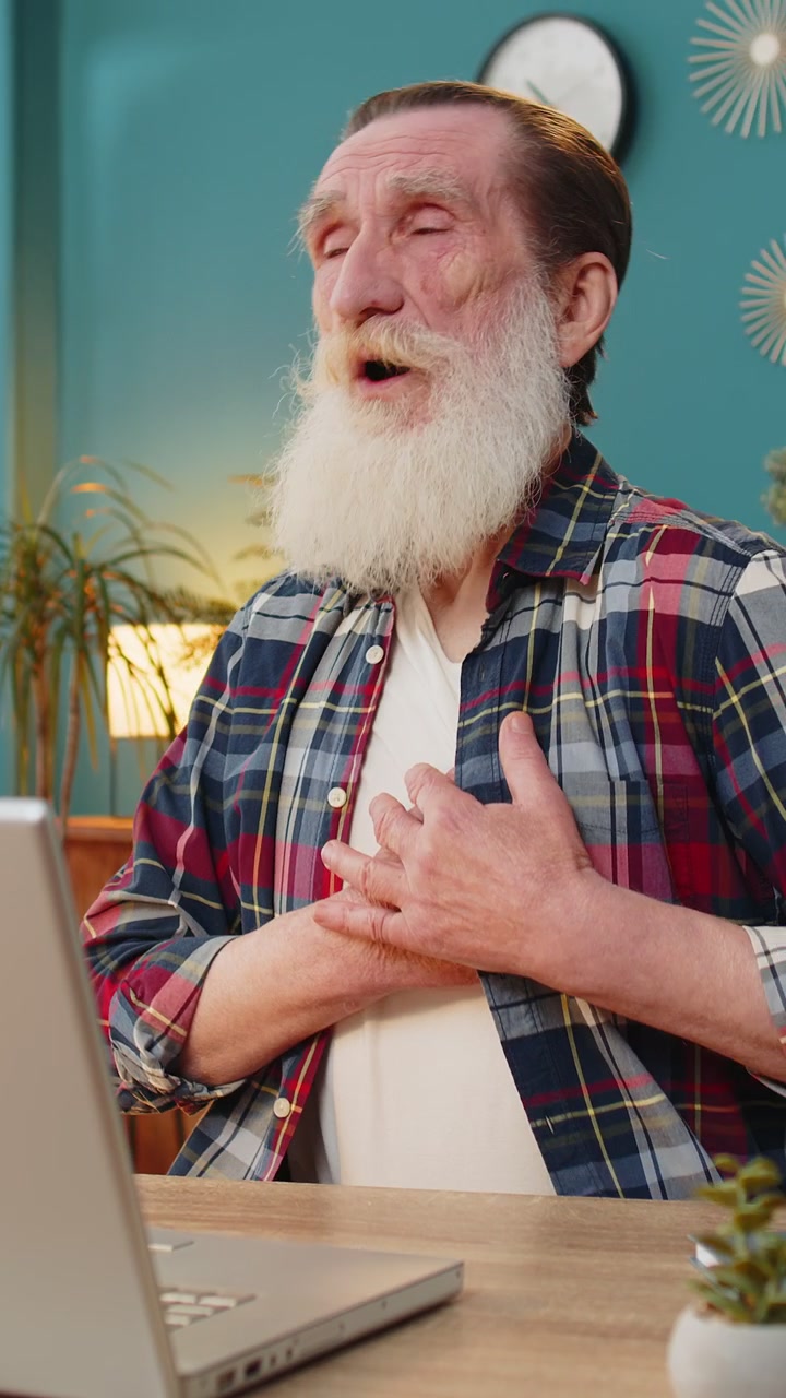 Elderly old man freelancer suffers from tension holding chest with heart pain attack risk of stroke