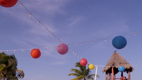 linternas de papel suspendidas en un cable en un salón en un resort mexicano