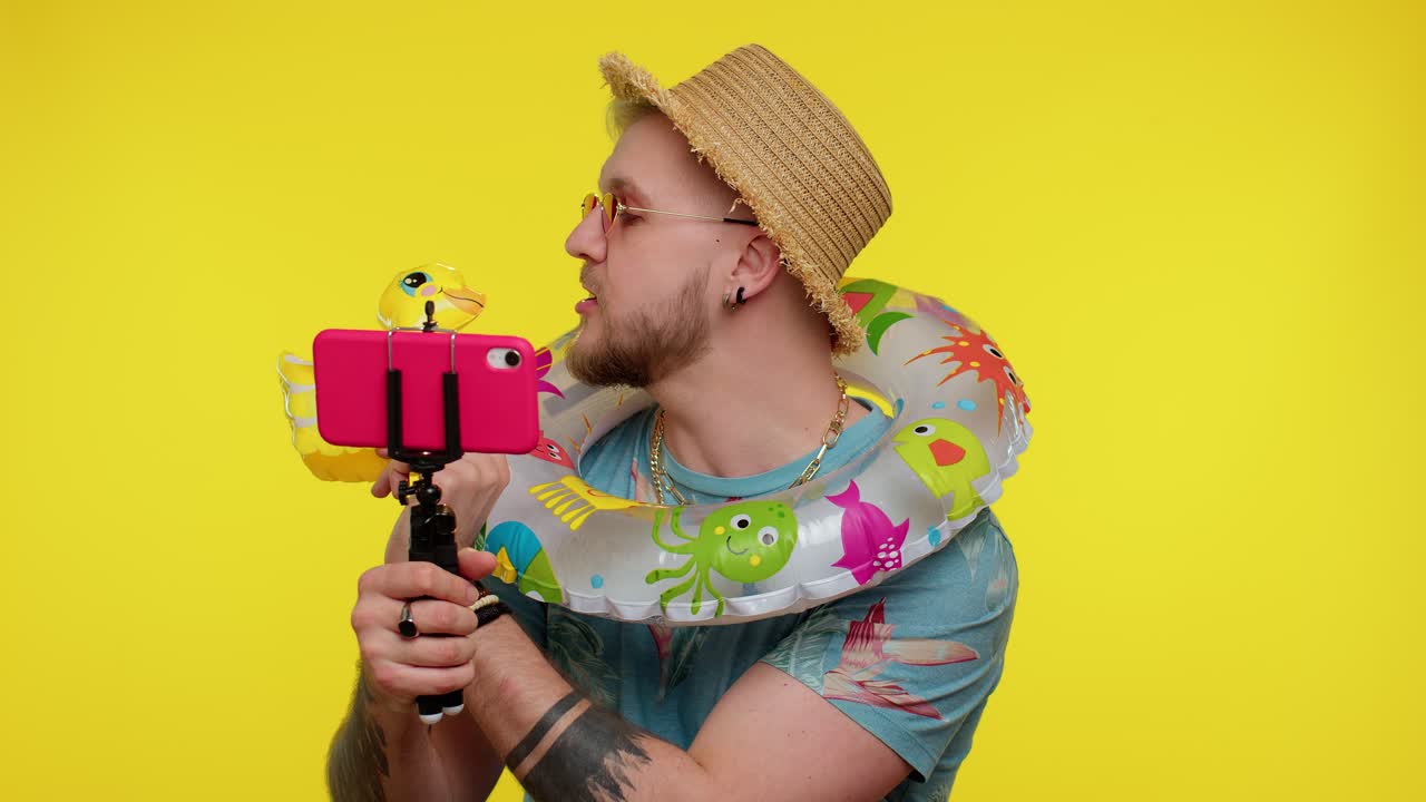 모자와 선글라스를 입은 남자가 부풀어올릴 수 있는 반지를 착용하면서 셀피를 찍습니다.