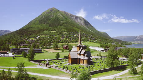 Panorama-De-La-Iglesia-De-Madera-De-Lom-Con-La-Montaña-Al-Fondo-En-Noruega