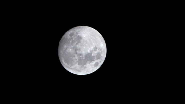 Close-up da Lua Cheia iluminada a pôr-se, time-lapse da paisagem noturna.