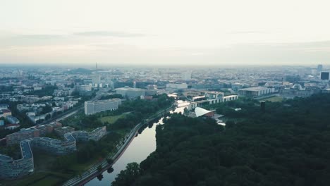 Pan-Aéreo-De-Drones-A-La-Izquierda-Hacia-La-Ciudad-De-Berlín-Con-Un-Río-Durante-El-Amanecer