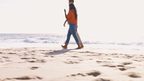 Talking,-date-and-a-couple-walking-on-the-beach