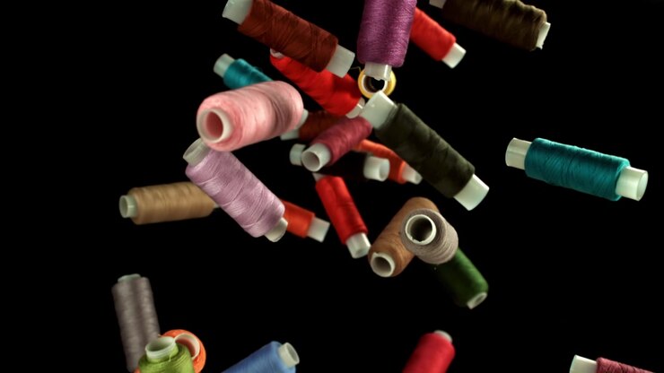 Colorful Spools of Sewing Thread Falling in Slow Motion