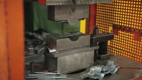 Factory-Worker-using-Industrial-Bending-Machine-with-Pair-of-Tongs-to-Manufacture-an-Aluminium-Plate