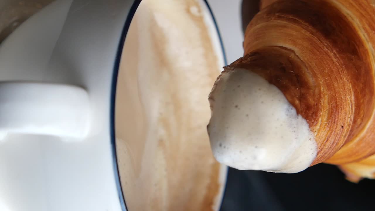 Croissant dipped in coffee