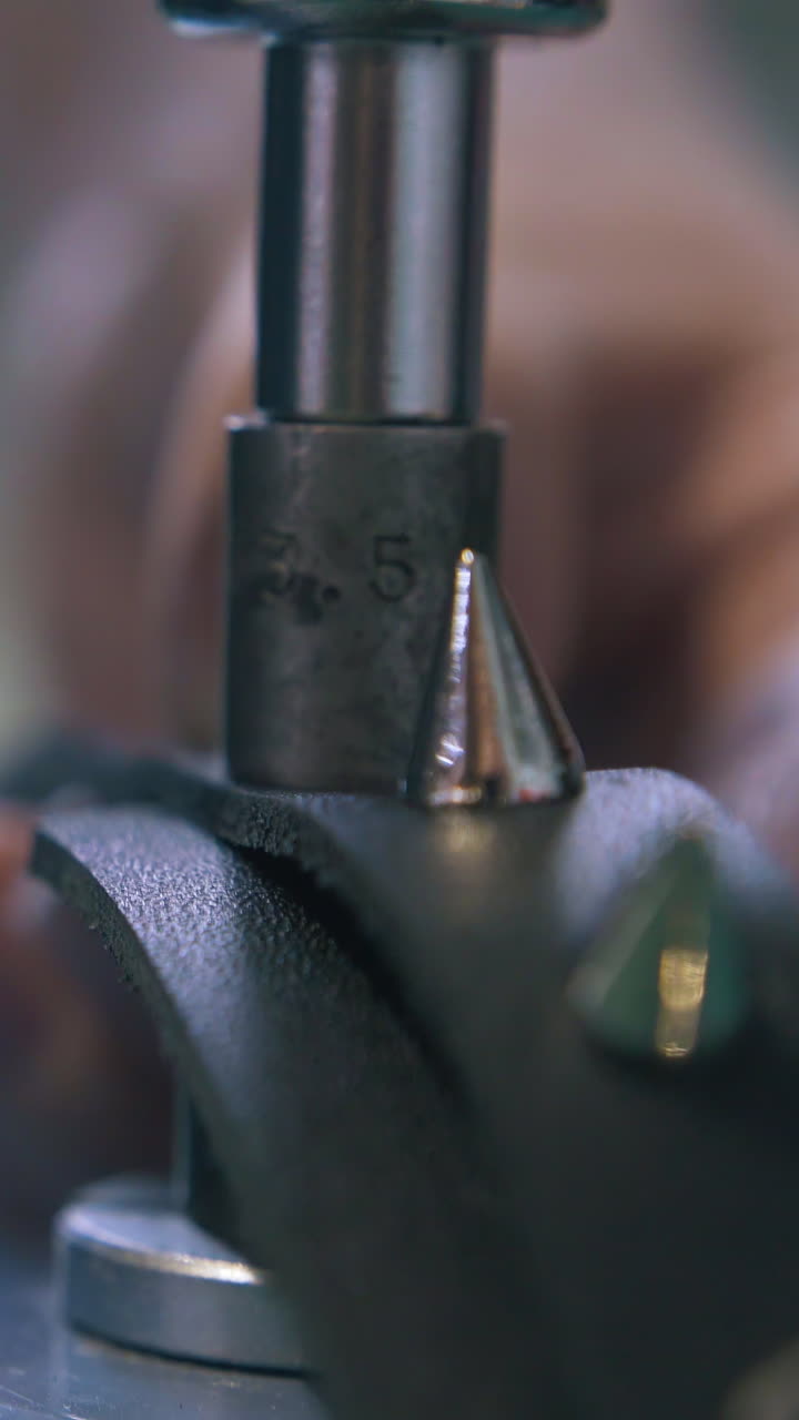 CU: Professional worker sets stylish leather choker accessories with special press machine extreme close view