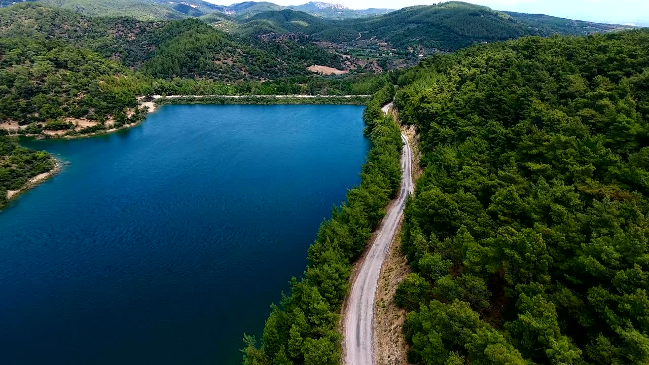 Vista aerea. Volo sopra il bellissimo lago e la foresta. Giornata di sole. Ripresa con telecamera aerea. Panorama paesaggistico.