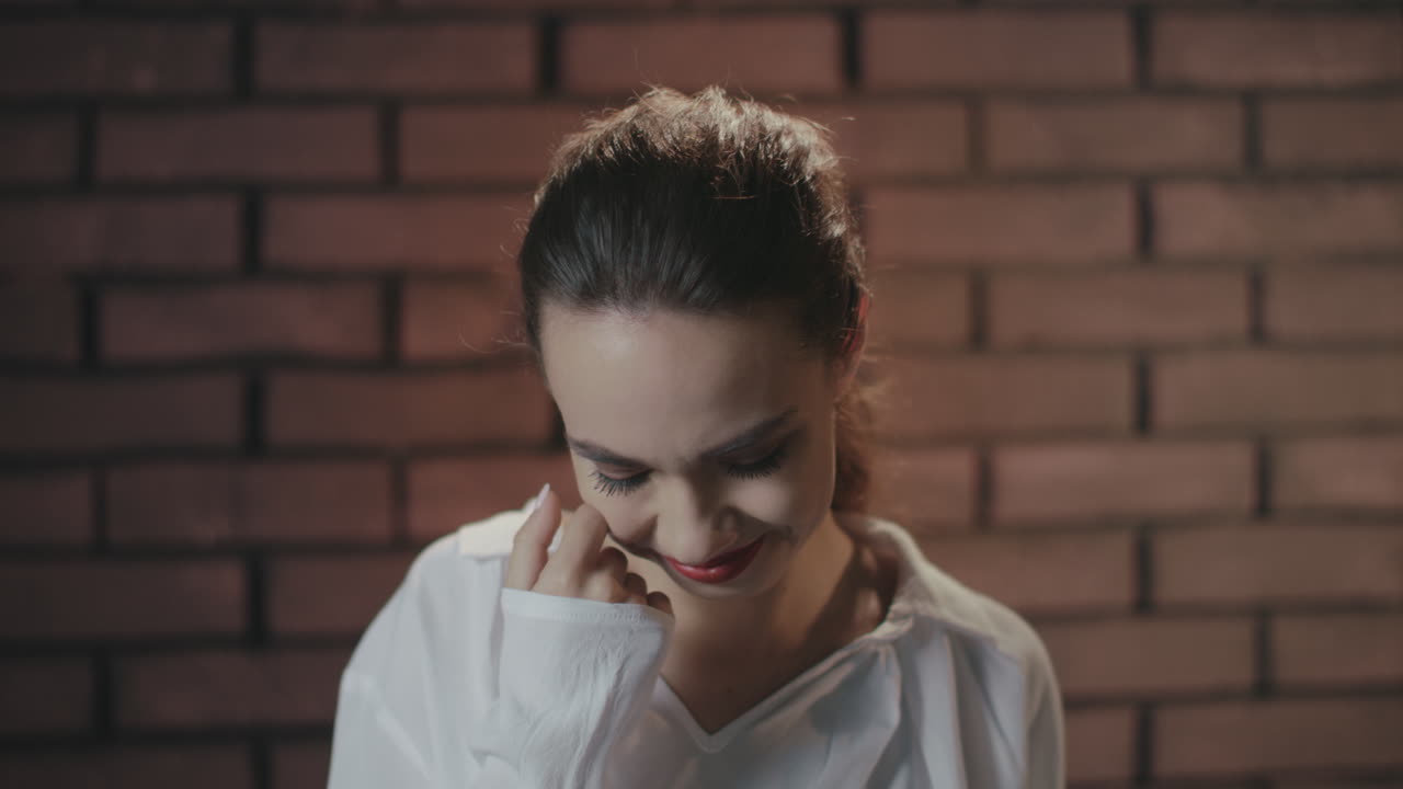 una mujer bonita riendo y escondiendo una sonrisa con las manos.