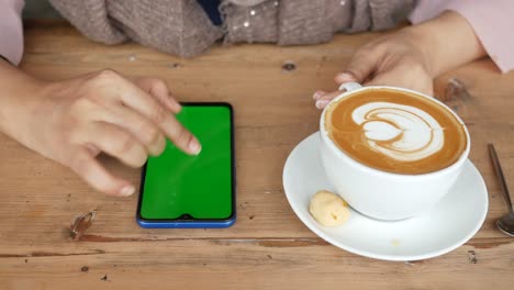 holding a cpu of coffee and using smart phone with green screen