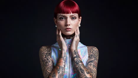 a striking portrait of a model showcasing vibrant red hair, intricate tattoos, and a futuristic holographic outfit, captured against a dark backdrop