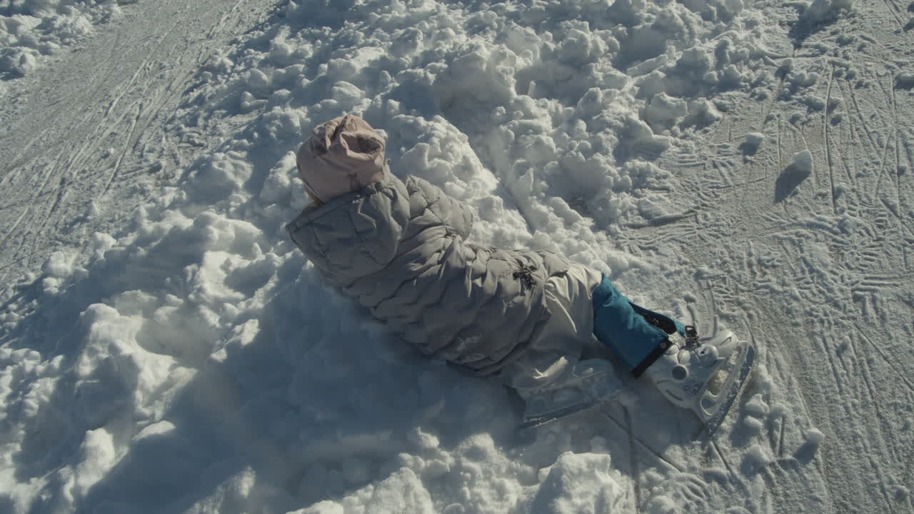 체코 공화국 코코린에 있는 lhotka 얼어붙은 호수에서 동료 스케이터들이 지나가는 것을 보고 눈 속에 빠진 작은 아이스 스케이팅 소녀 - 중간 높은 각도 샷