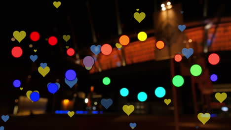 animación de puntos y corazones flotando sobre el paisaje urbano nocturno borroso