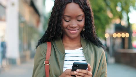 close-up view of african american woman using smartphone in the street