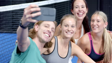 group of young adults sitting on indoor court discussing padel tennis strategy together