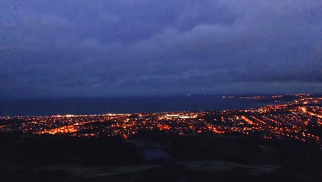 A-slow-pan-across-the-city,-from-a-mountain-at-night