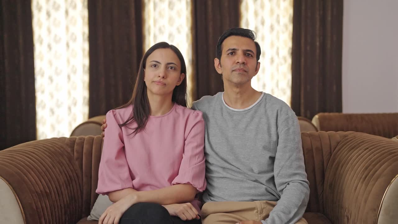 pareja india viendo la televisión en casa