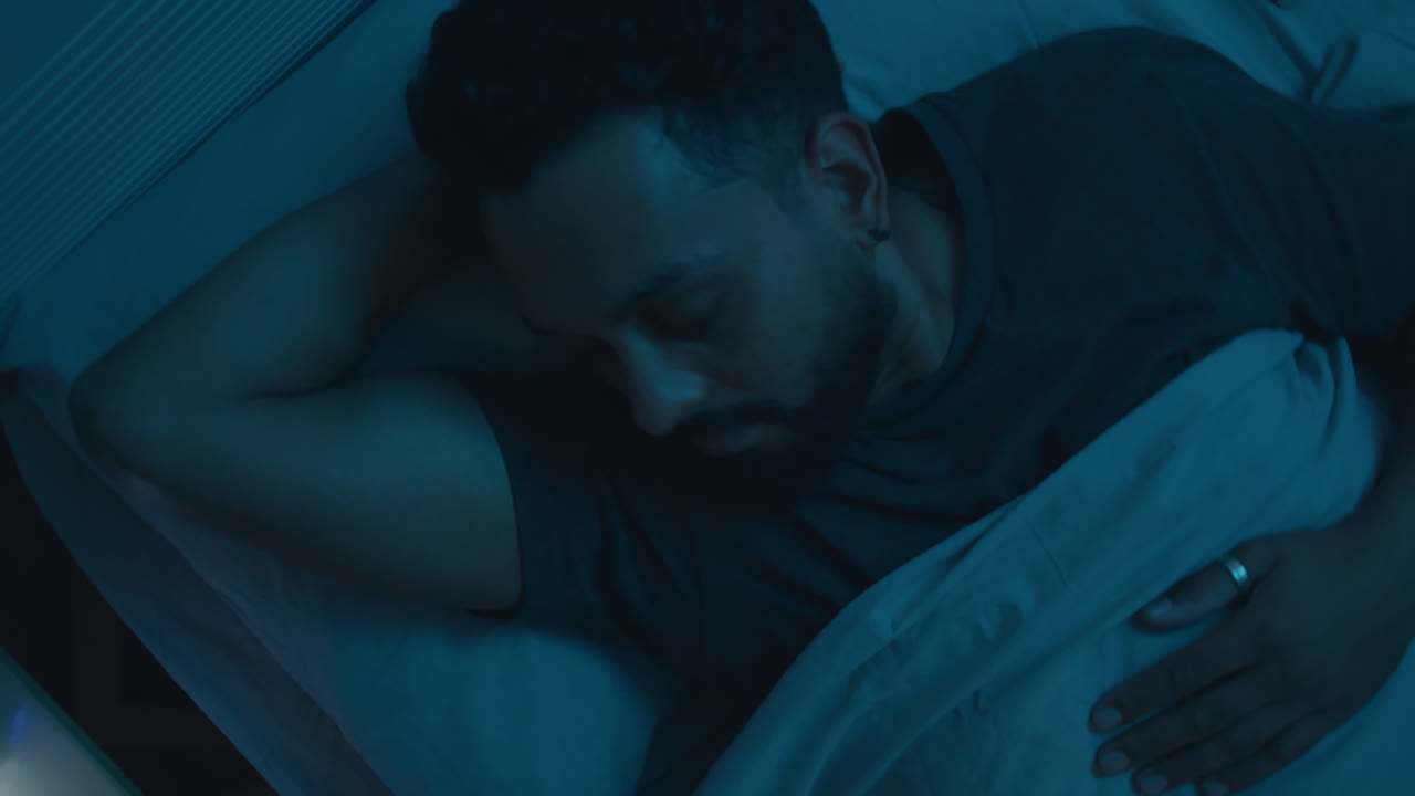 hombre durmiendo en la cama por la noche