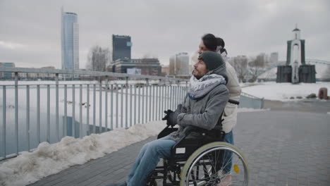 muslim woman and her disable friend looking at something in the distance in city in winter 1