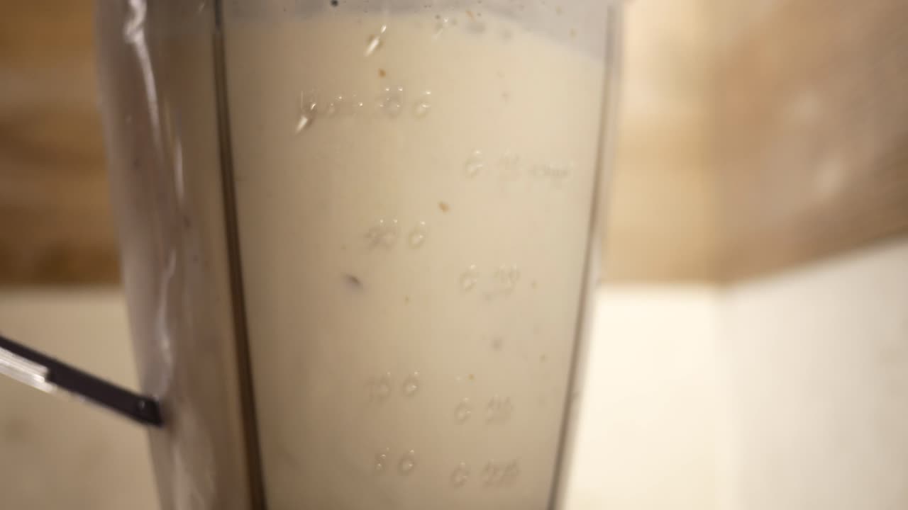 primer plano de una licuadora llena de un batido blanco