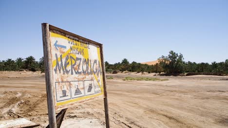 sign of the maison guesthouse in merzouga near an oasis in high sand dunes of the sahara in merzouga,erg chebbi, morocco