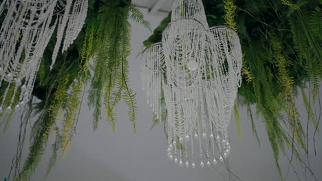 elegant crystal chandeliers adorned with hanging green foliage, creating a luxurious atmosphere