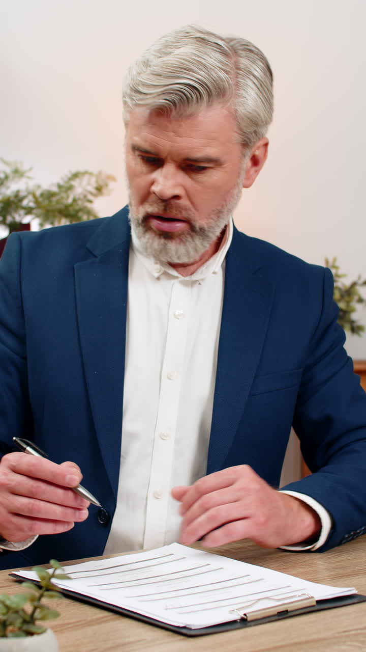 Middleaged businessman spots invoice error fixes figures with pen then signs key papers confidently