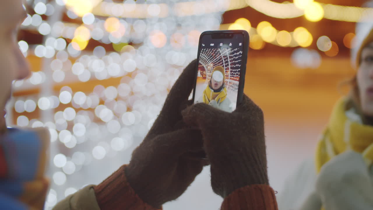Man Taking Picture of Girlfriend in Tunnel of Christmas Lights