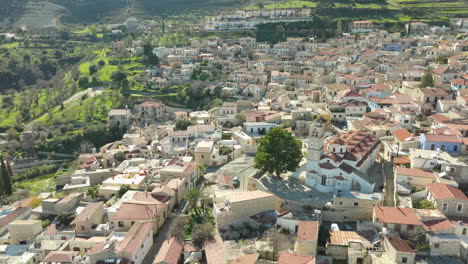 Una-Perspectiva-Aérea-Muestra-El-Denso-Grupo-De-Edificios-Históricos-De-Lefkara-Y-La-Iglesia-Central-Que-Se-Erige-Como-El-Corazón-Del-Pueblo,-La-Exuberante-Vegetación-De-La-Campiña-Chipriota.