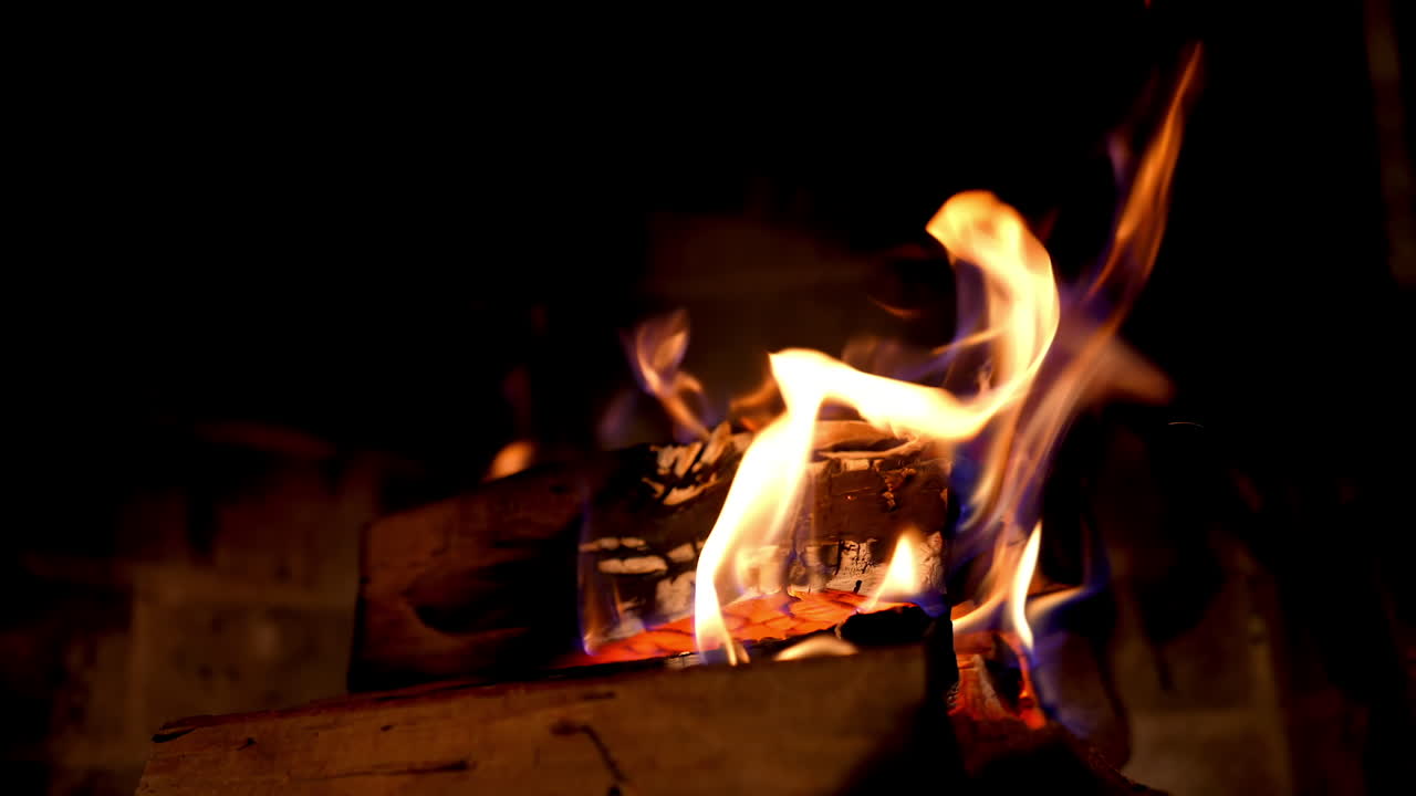 Fireplace with burning fire. Firewood combustion in fire at night. Warmth and comfort at home. Cozy fireplace in winter. Close-up.