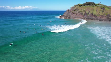 surfers enjoying ocean waves at cabarita beach in new south wales, australia - aerial shot