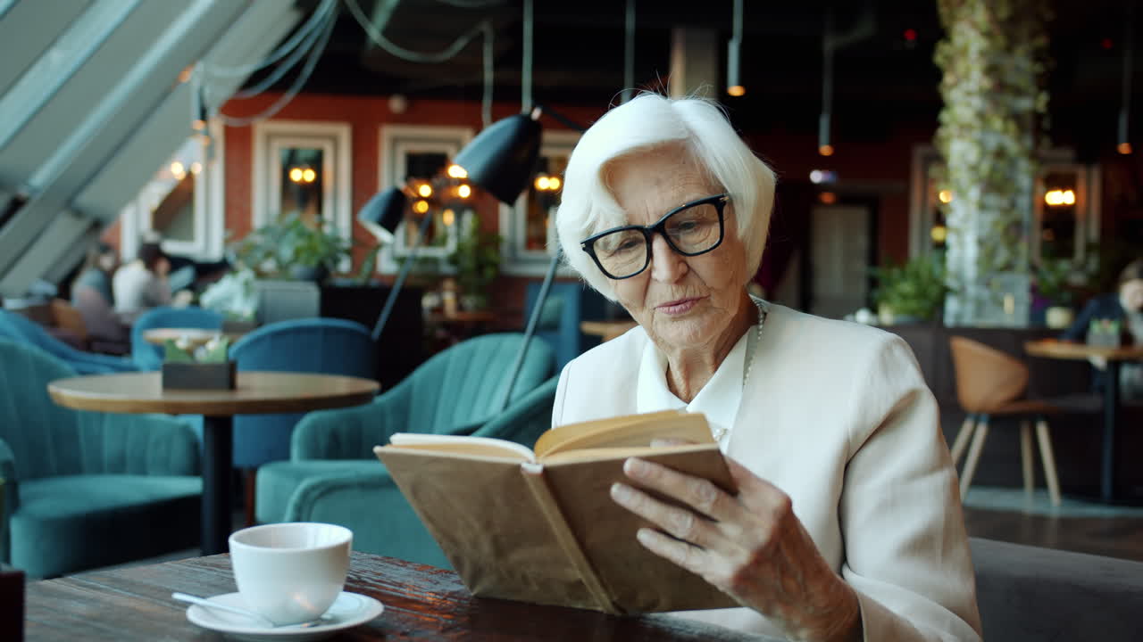 Une femme âgée lisant dans un café