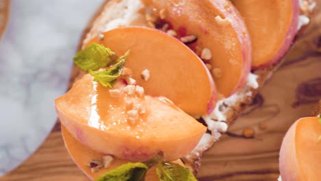 peach ricotta toasts garnished with walnuts, fresh mint, and raspberries