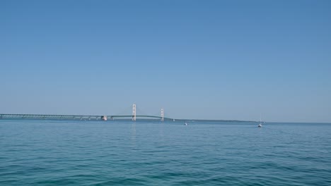 boat view of mackinac bridge and sailboat, michigan