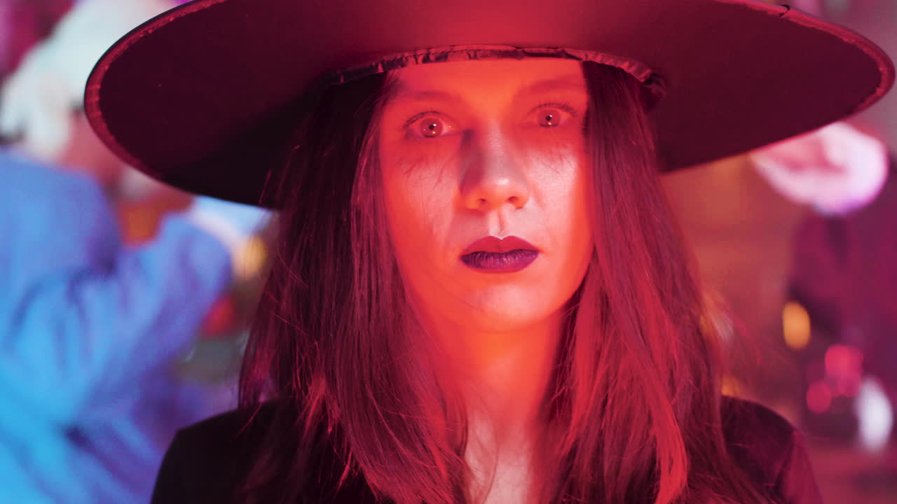 A woman dressed as a witch at a Halloween party