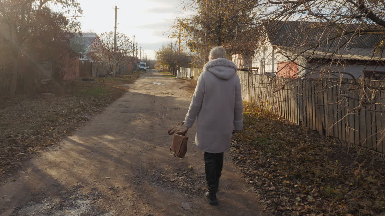 시골 의 가을 도로 를 고 있는 여자