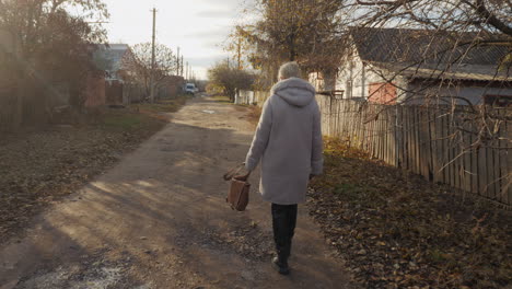 woman walking down a rural autumn road