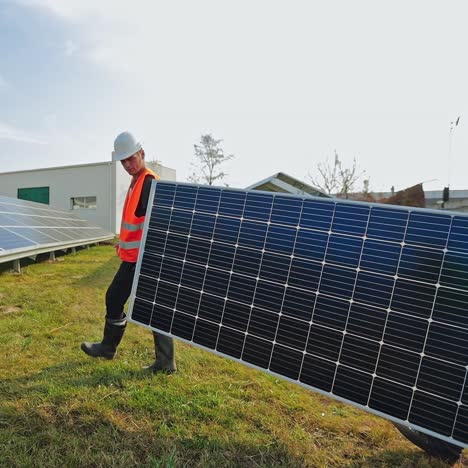 workers carry solar panel to install on the grass. technicians working with sunny battery on the farm. alternative green energy.